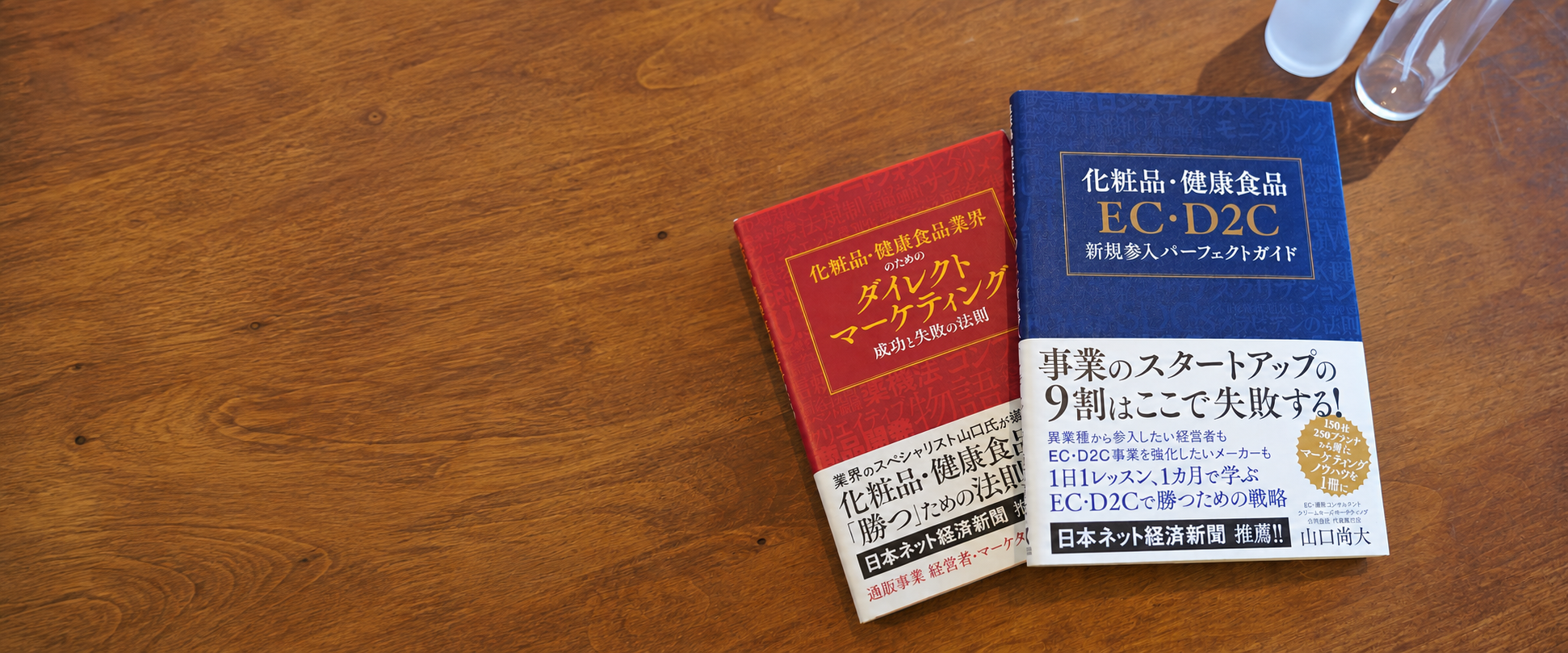木のテーブルに並べた山口尚大の著書2冊