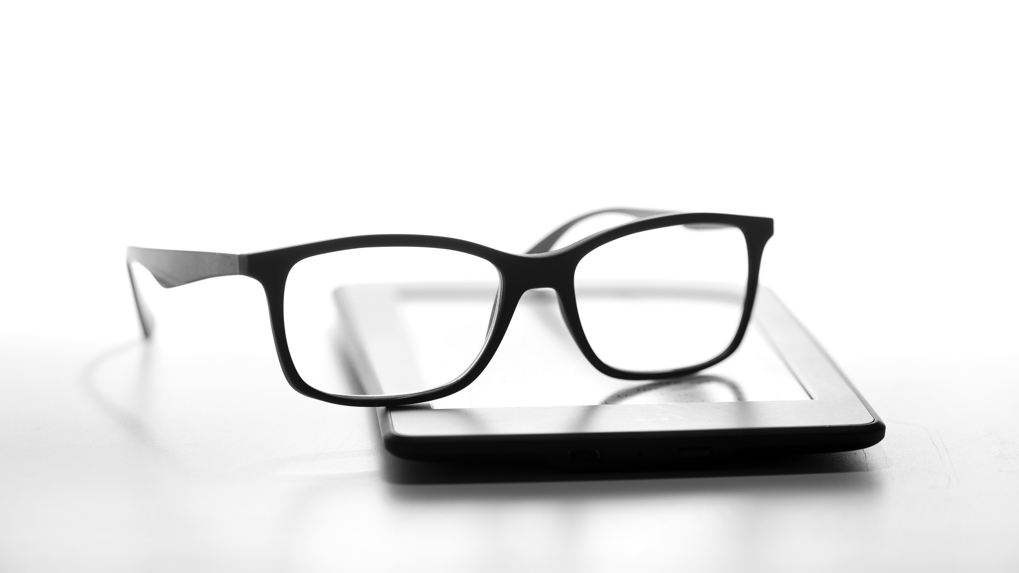 Reading glasses resting on an e-book