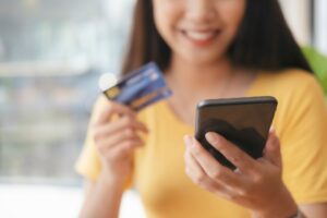 Business woman holding smartphone with credit card for pay online shopping e-commerce .
