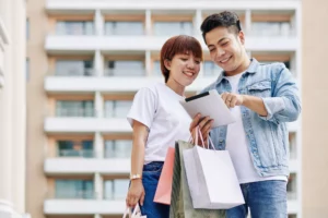 Couple With Shopping Bags And Tablet PC