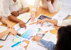 Logo, branding and team of designers in a business meeting collaboration planning and designing a c