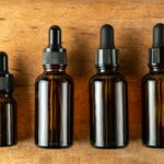 Serum bottles on wooden background. Sustainable lifestyle concept, natural cosmetics. Unbranded Cosm