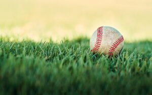 Its baseball time. Shot of a baseball lying on a field.